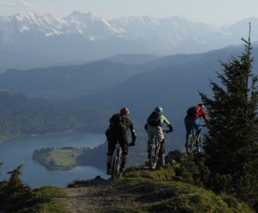 Three people on mountain bikes in a mountainous landscape